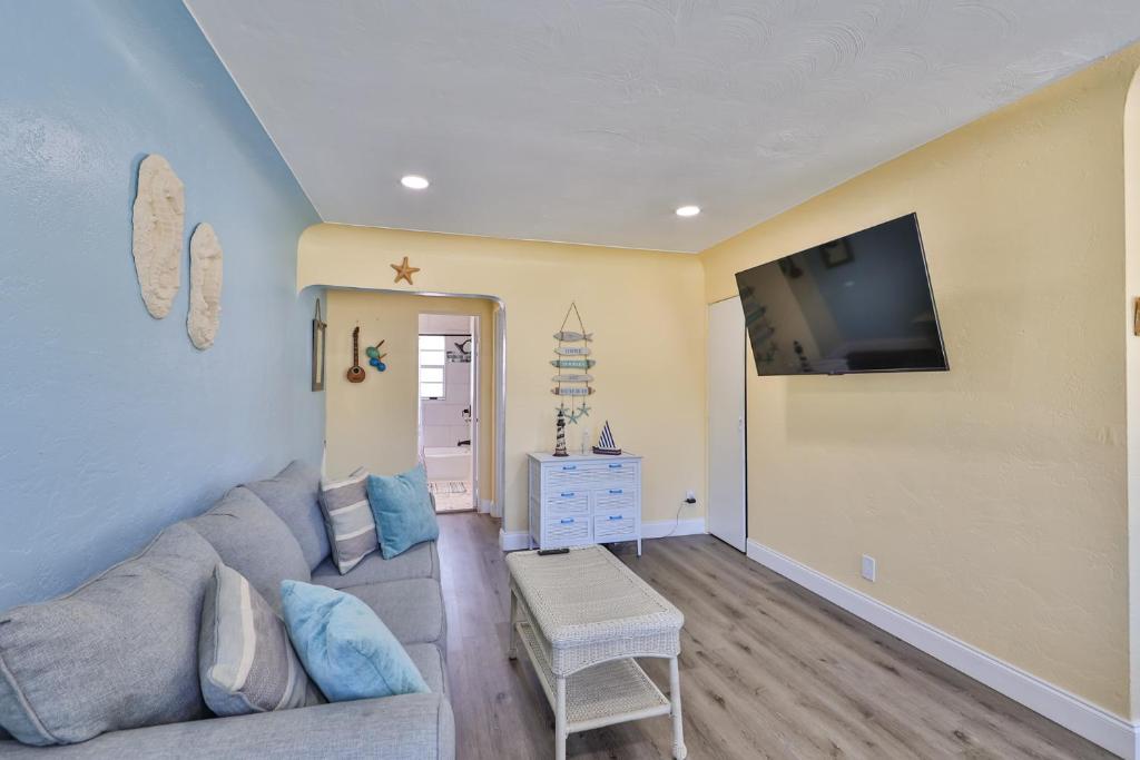 a living room with a couch and a flat screen tv at Gorgeous Beach Condo in St Petersburg