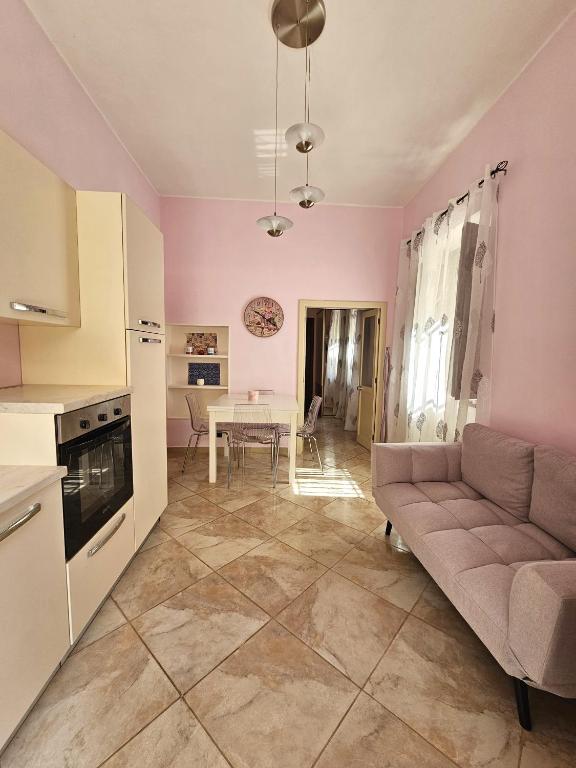 ein Wohnzimmer mit einem Sofa und einem Tisch in der Unterkunft Pink Place in Policoro
