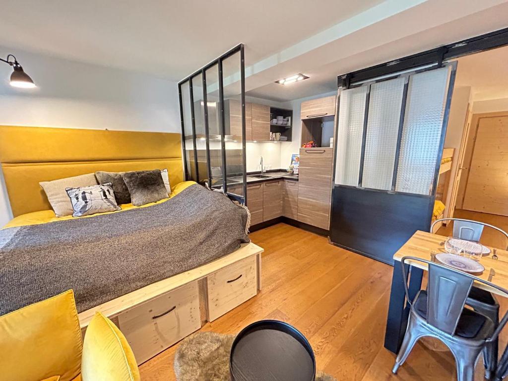 ein Schlafzimmer mit einem Bett und einem Schreibtisch sowie eine Küche in der Unterkunft Studio Les Gets, 1 pièce, 4 personnes - FR-1-623-34 in Les Gets