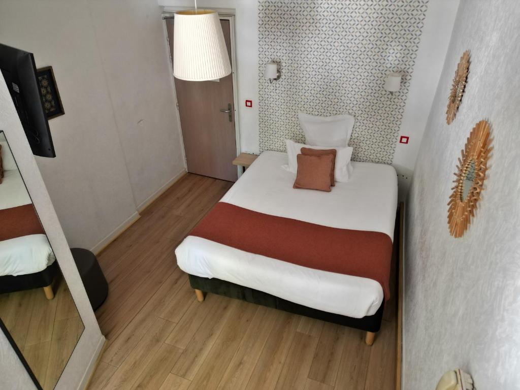 a small room with a bed and a staircase at Hôtel les Platanes in Villeneuve-sur-Lot
