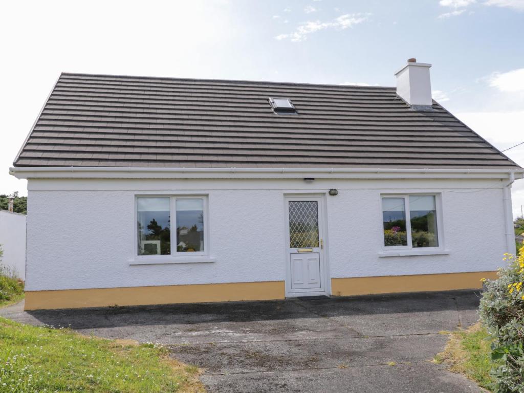 a white house with a black roof at Kincasslagh in Gortnasate