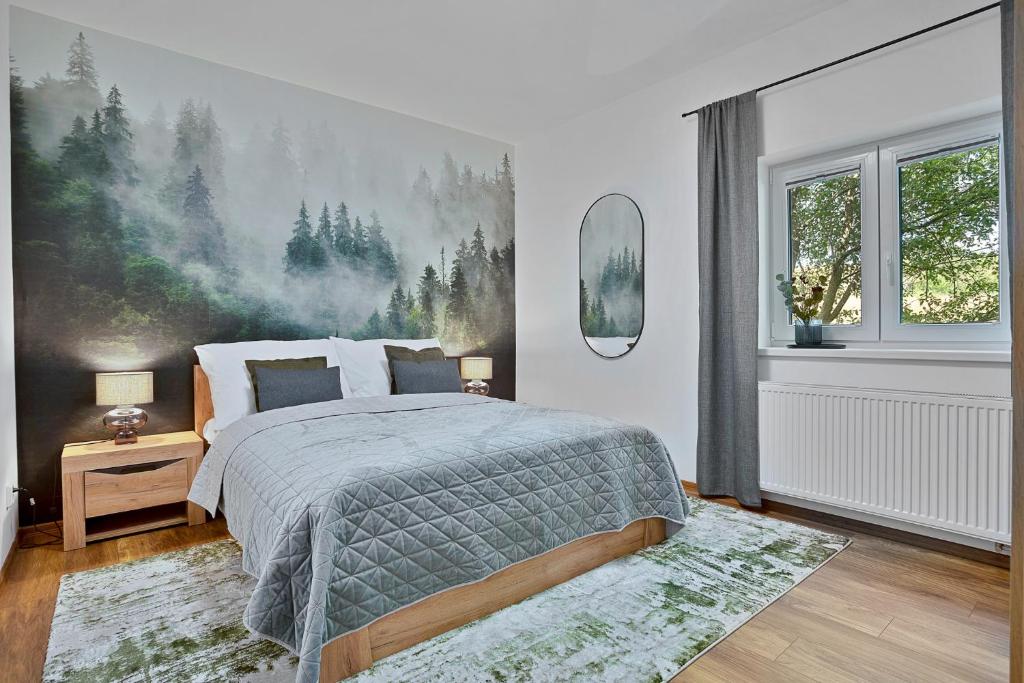 een slaapkamer met een bed en een groot schilderij aan de muur bij Krušné Apartmány in Loučná pod Klínovcem
