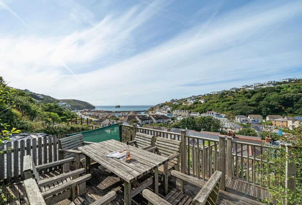 a picnic table on a deck with a view of the ocean at The Boy's Cottage in Portreath