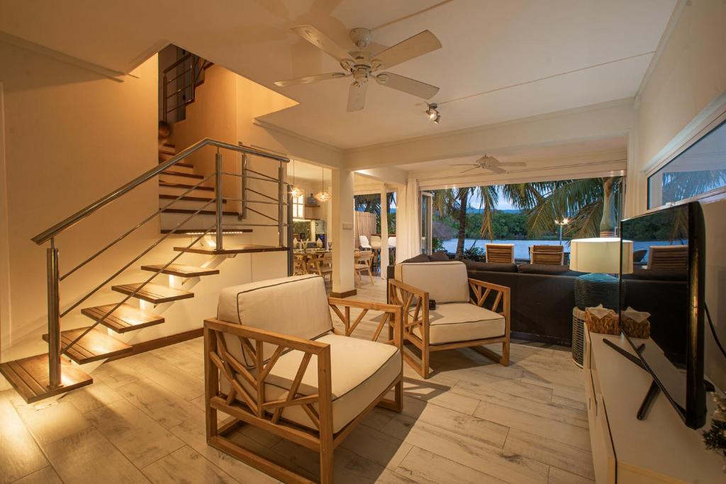 a living room with a spiral staircase and chairs at Between 2 waters Villa, free rental car offered. in Tamarin
