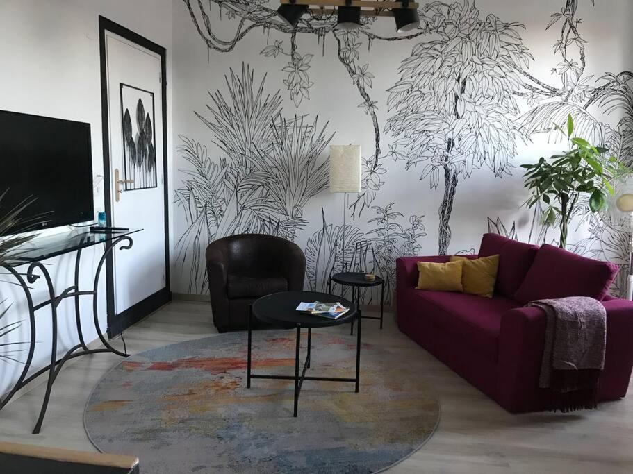 un salon avec un canapé violet et une table dans l'établissement Superbe T2 dans un parc arboré, à Lamalou-les-Bains