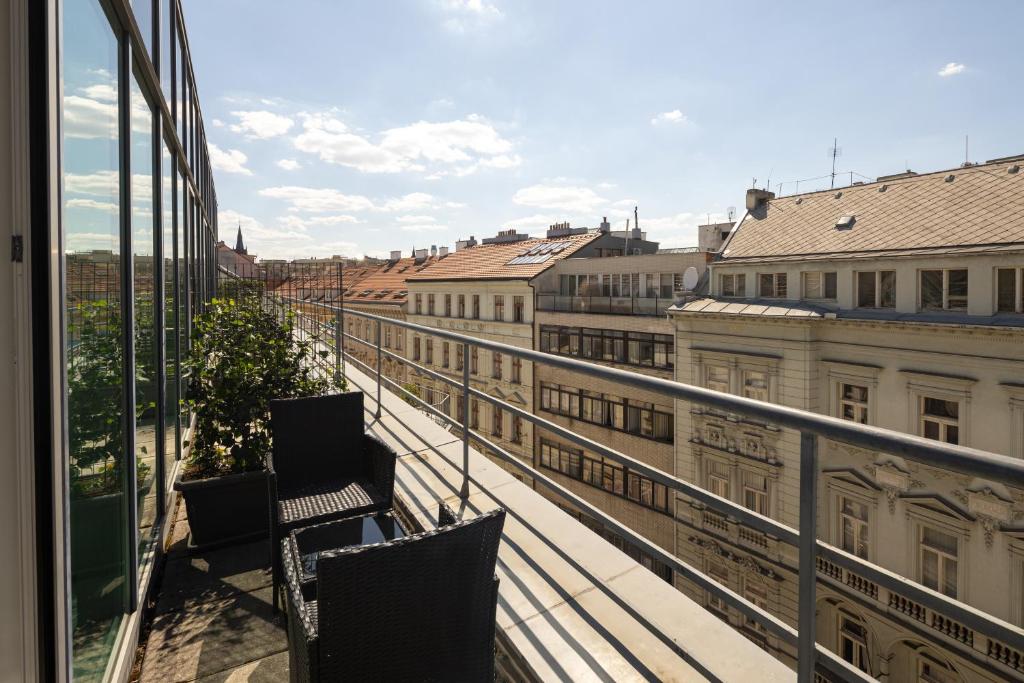 een balkon met 2 stoelen en uitzicht op de stad bij K+K Hotel Fenix in Praag