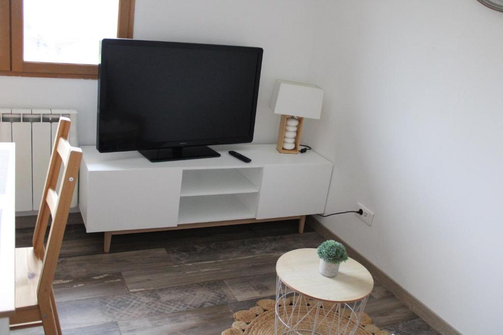 a living room with a tv on a white cabinet at ISA ET LIO in Chavanod