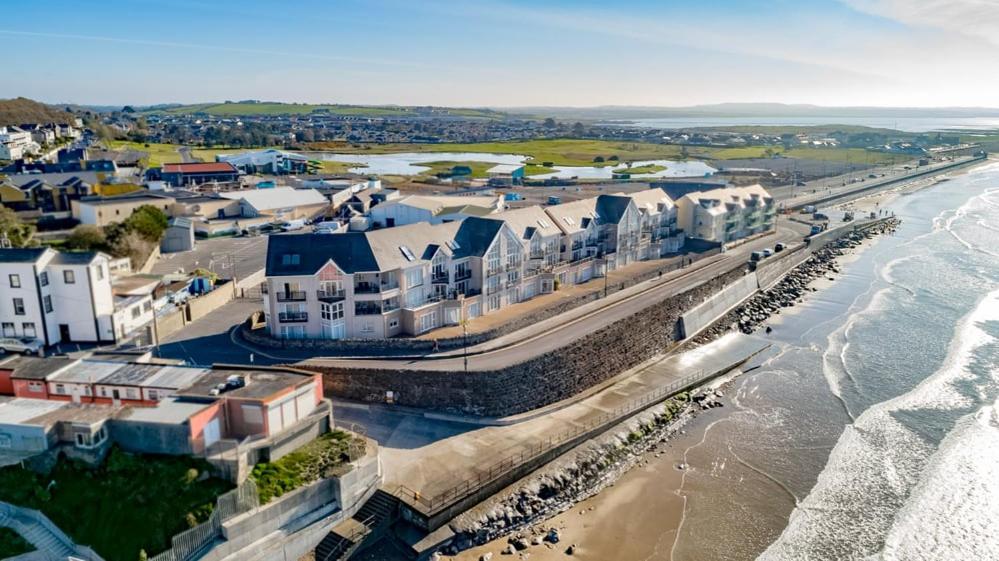 eine Luftansicht auf einen Strand mit Gebäuden und das Meer in der Unterkunft Holiday Apartment Iris in Waterford