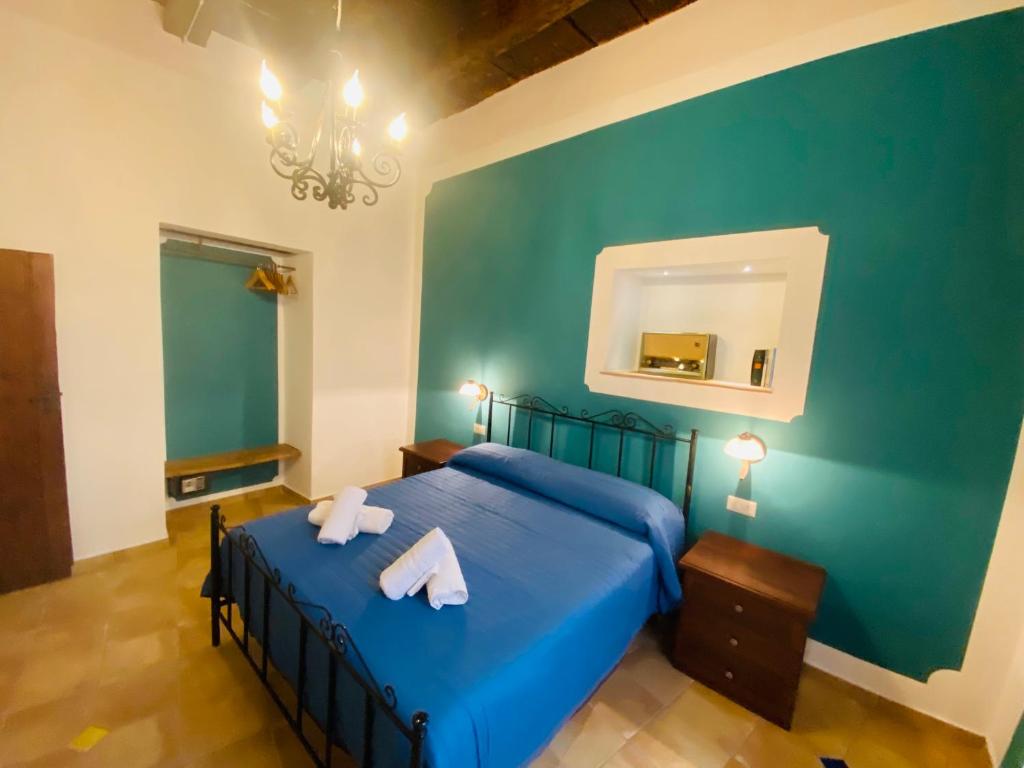 een slaapkamer met een blauw bed met 2 handdoeken erop bij Verderame - Apartment in Licusati