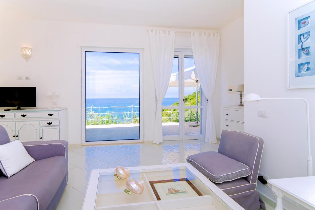 a living room with a couch and a tv and a balcony at Blu OltreMare in Acciaroli