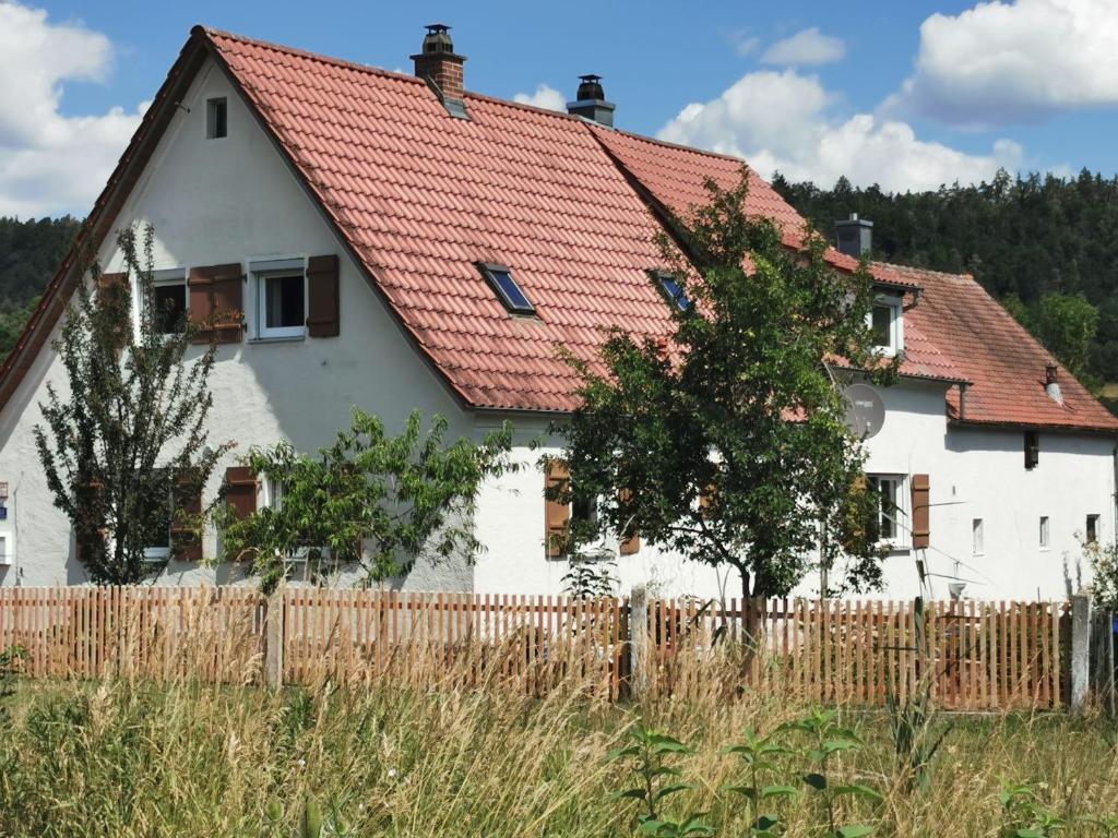 ein weißes Haus mit rotem Dach in der Unterkunft s´Paradies Ferienwohnung in Beilngries