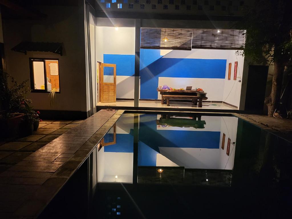 a house with a swimming pool at night at Exotic Backpackers in Banyuwedang