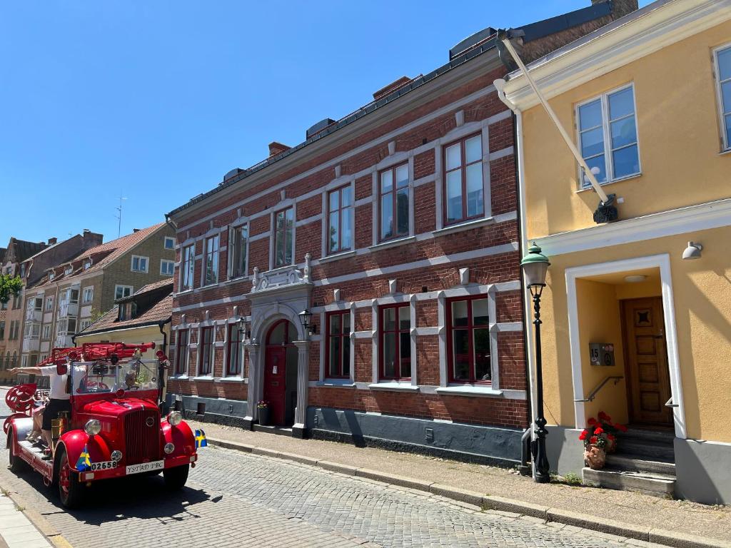 an old red fire truck parked on a street at Villa Brigitta, havsnära boende mittemot Klostret i Ystad centrum in Ystad