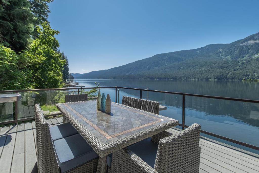 a table and chairs on a deck with a view of a lake at All About the Lake by NW Comfy Cabins in Leavenworth