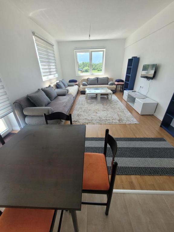 ein Wohnzimmer mit einem Sofa und einem Tisch in der Unterkunft Apartman Stan شقة in Plav