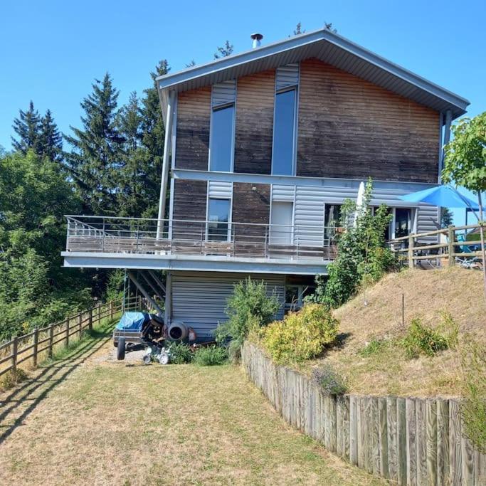 une maison au sommet d'une colline avec une clôture dans l'établissement Splendide villa d architecte ; massif du pilat, à Planfoy