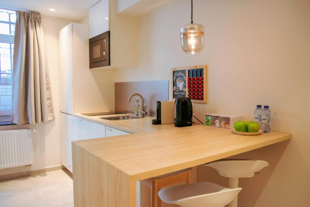 a kitchen with a wooden counter top in a room at Archimède Suites in Brussels