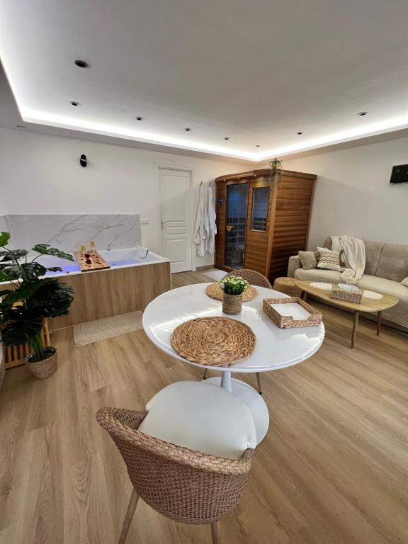 een woonkamer met een tafel en een bank bij L’Eden d’Opale in Coquelles