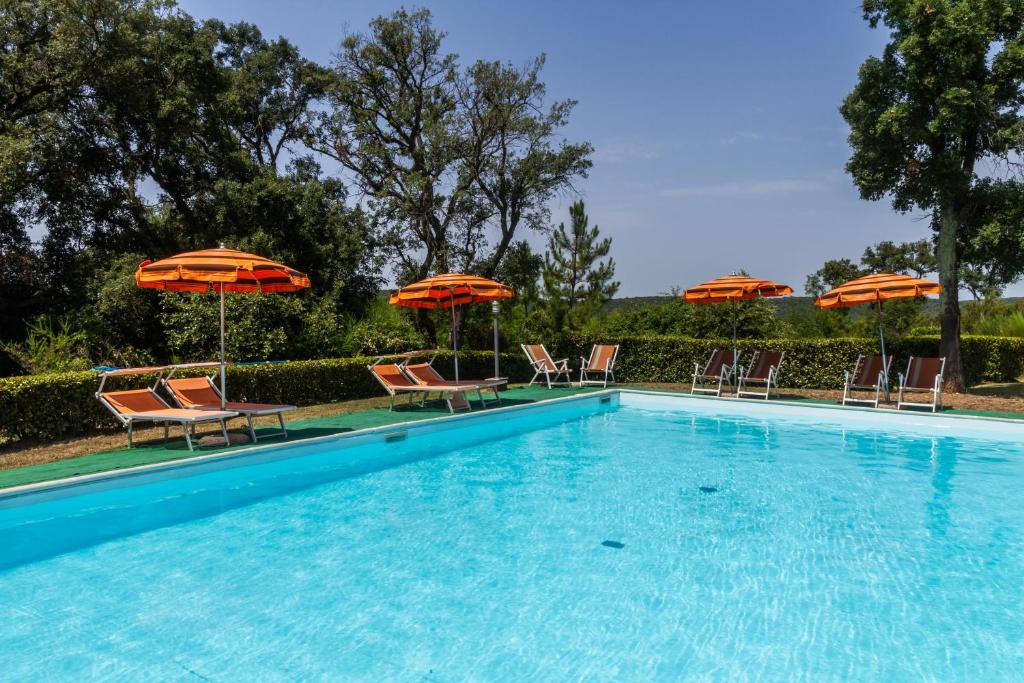een zwembad met stoelen en parasols bij Casa Vacanza Il Carpignone 7 in Massa Marittima