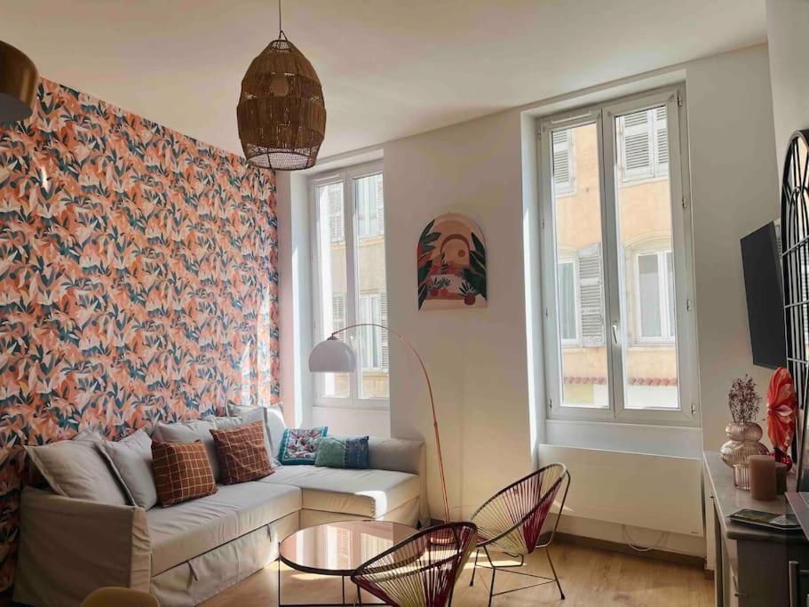 a living room with a couch and two windows at Pleasant 3-bedroom flat in the center of Marseille in Marseille