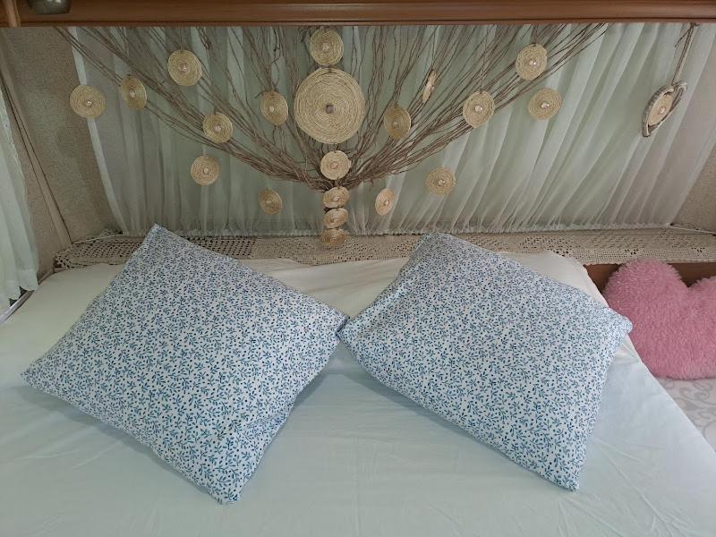 a bed with two pillows on top of it at Caravana Villa Rosa in Málaga