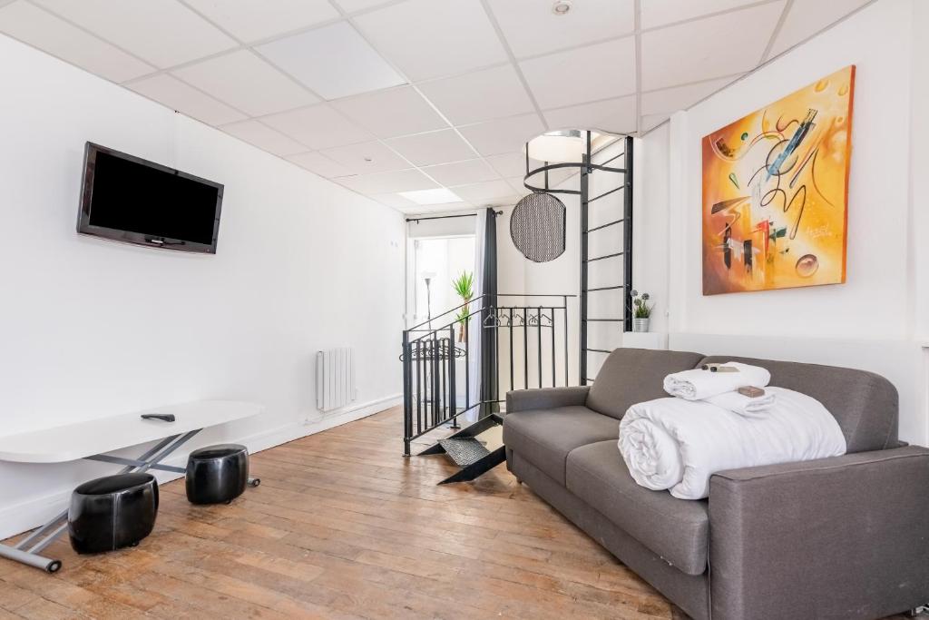 ein Wohnzimmer mit einem Sofa und einem Flachbild-TV in der Unterkunft Stylish Accommodation in the middle of Paris in Paris
