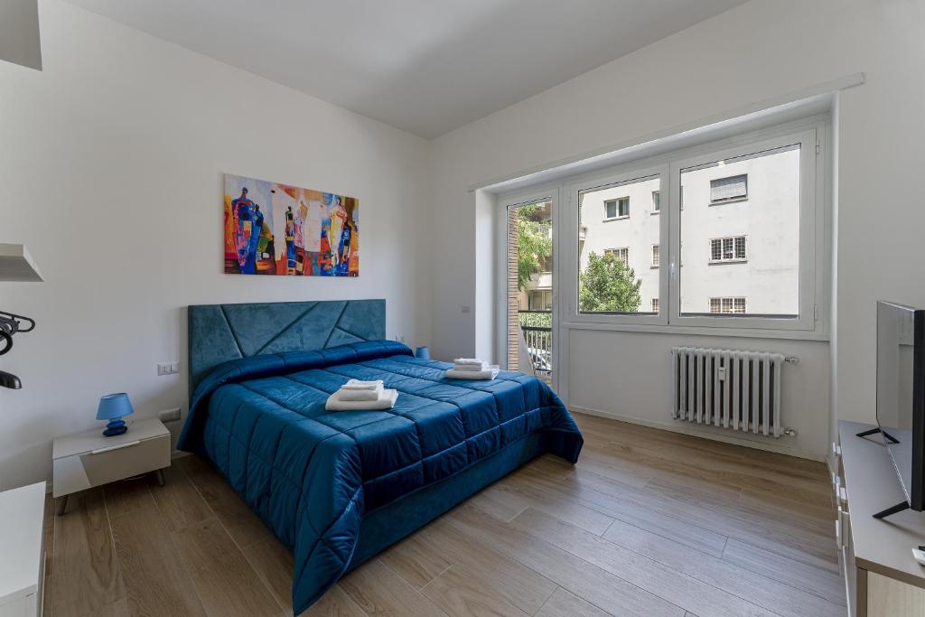 ein Schlafzimmer mit einem blauen Bett und einem Fenster in der Unterkunft Piazza Pio Suite Home in Rom