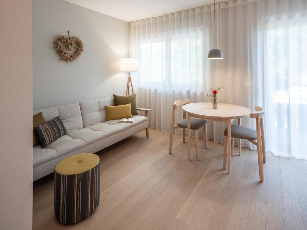 a living room with a couch and a table at Dianthus Apartment in Lana