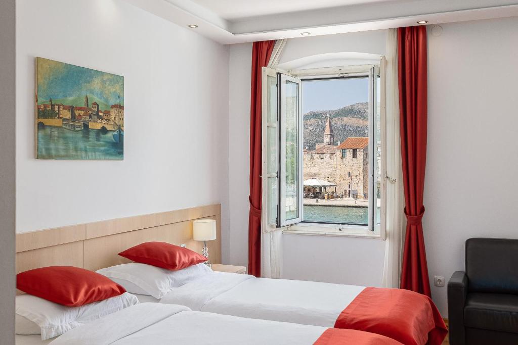 2 łóżka w pokoju hotelowym z oknem w obiekcie Heritage Hotel Vila Sikaa w Trogirze