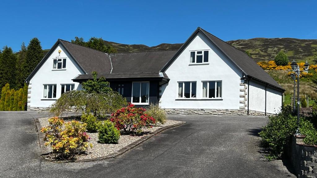 a white house with a black roof at Springburn Farmhouse in Spean Bridge