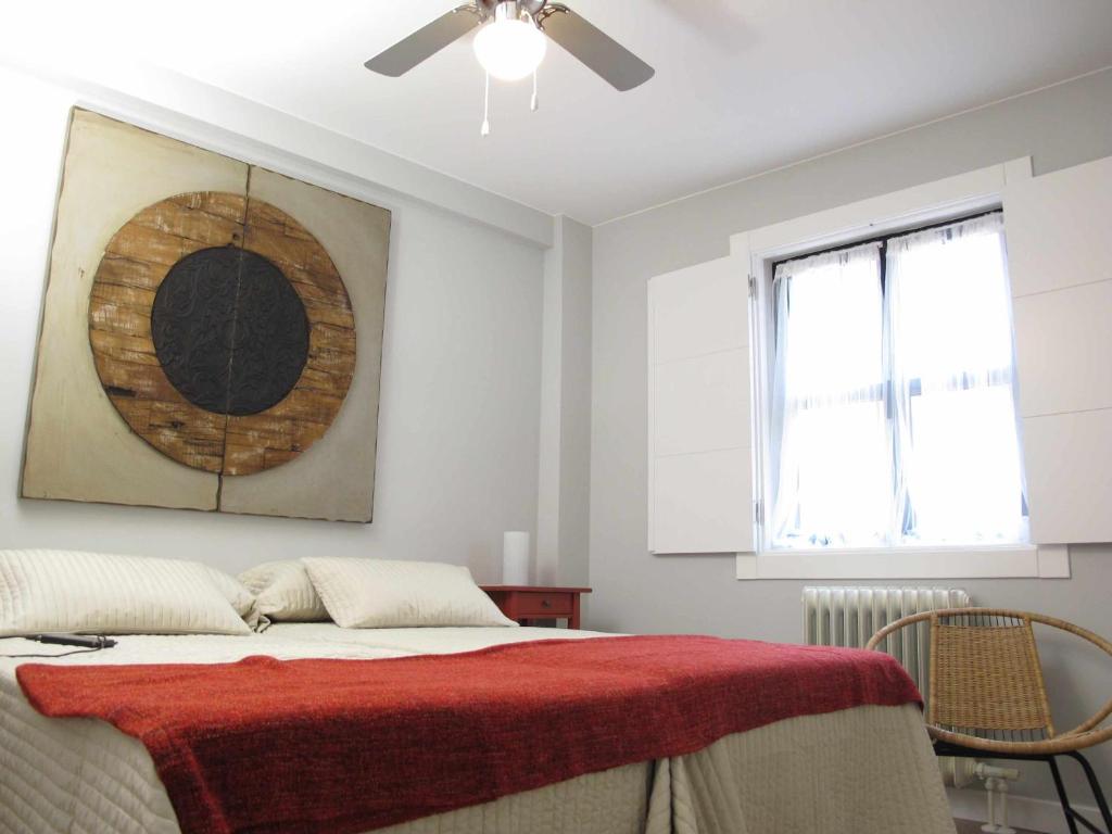 a bedroom with a bed with a red blanket on it at Casa Rota By KubiK in Cáceres