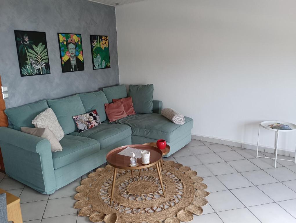 - un salon avec un canapé bleu et une table dans l'établissement Appart' cosy climatisé à 10' des plages et de Sète, à Frontignan