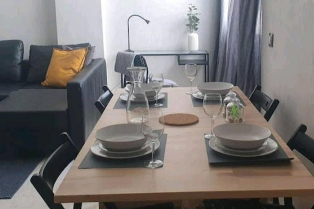 a dining room table with plates and wine glasses at Très bel appartement en face du parc, près du Novotel in Mohammedia
