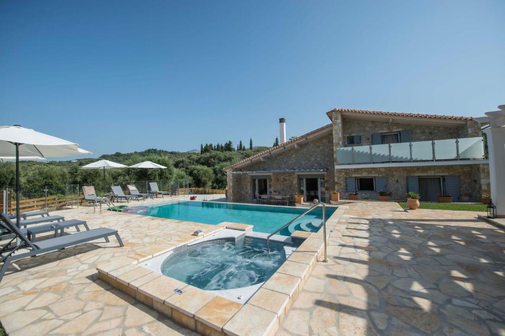 a villa with a swimming pool and a house at Villa Martha Perithia Corfu in Perítheia