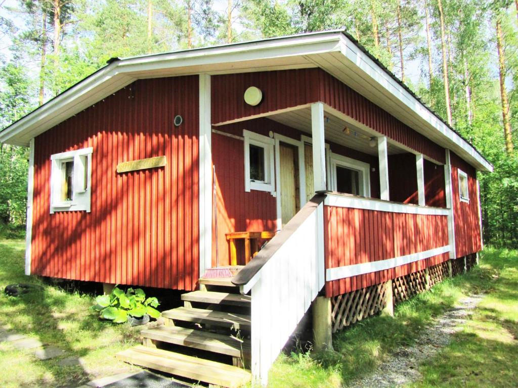 een rood huis met een trap naar de voorkant bij Lappalaisen lomamökit Suviranta in Puumala