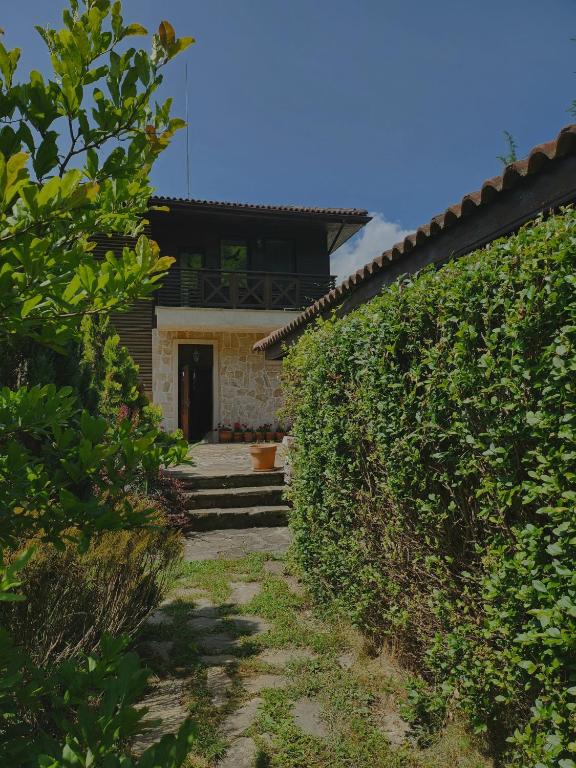 a house with a hedge in front of it at Eco Residence in Ribarica