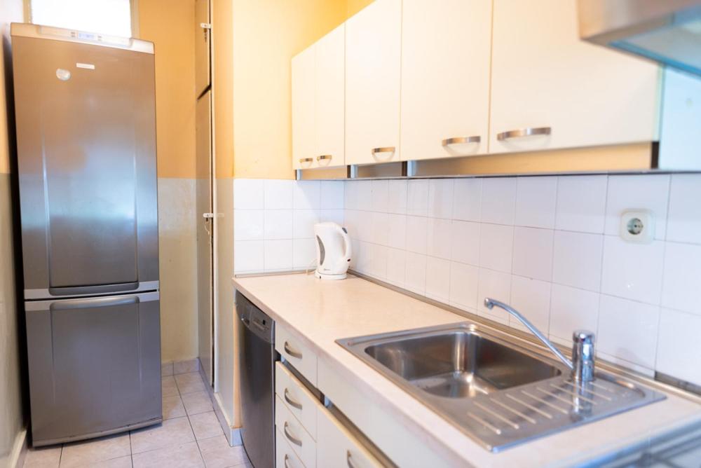 a kitchen with a sink and a stainless steel refrigerator at Apartment Duje in Split