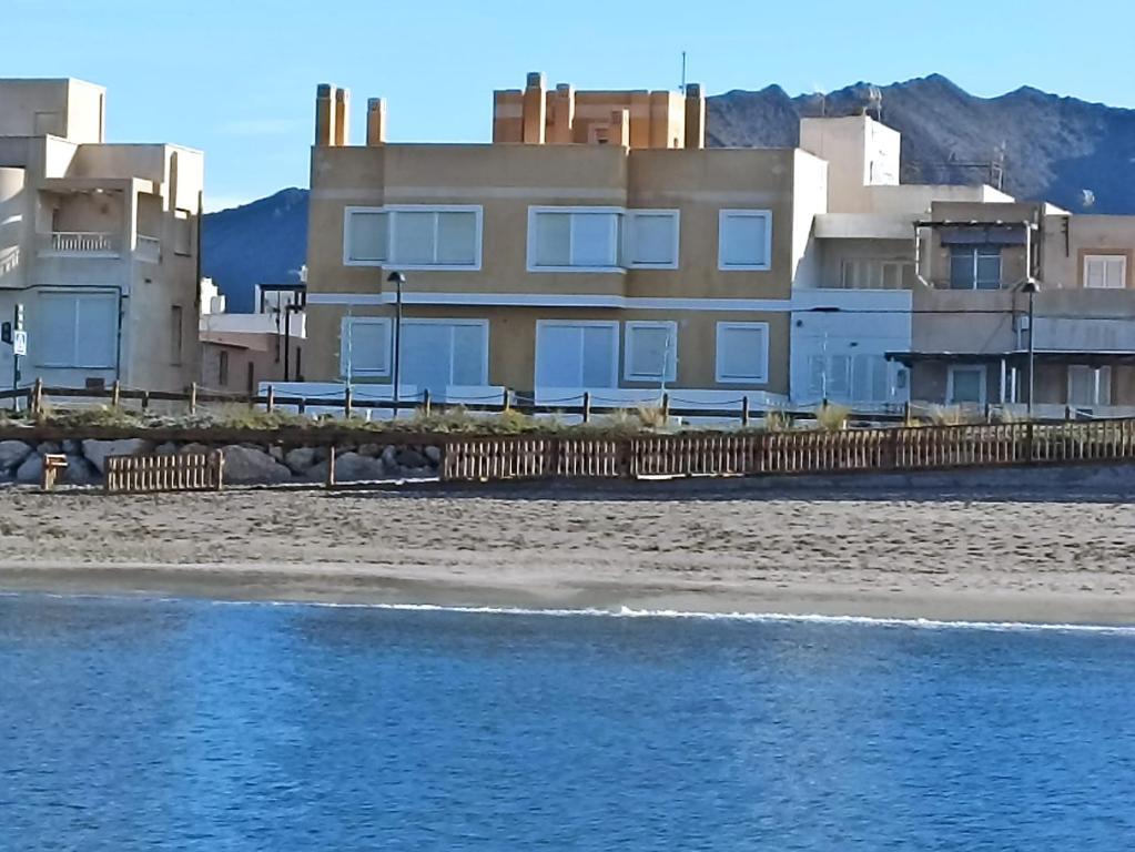 a house on the beach next to the water at Apartamentos La Calilla Cabo de Gata in El Cabo de Gata
