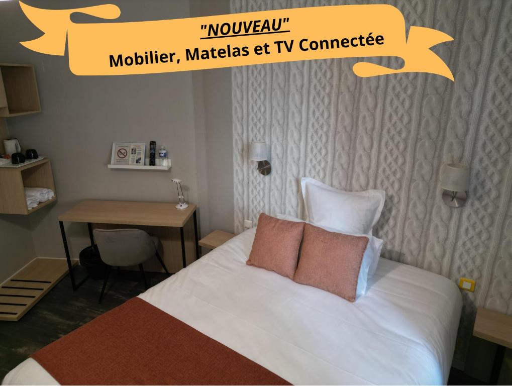 Habitación de hotel con cama con 2 almohadas y escritorio. en Hôtel les Platanes en Villeneuve-sur-Lot