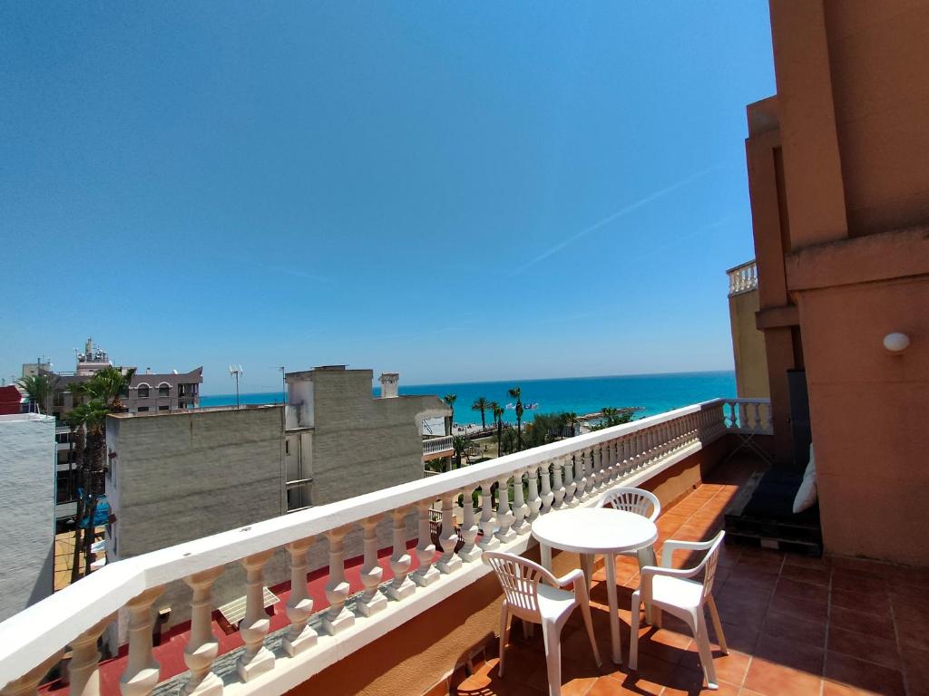 d'un balcon avec une table et des chaises donnant sur l'océan. dans l'établissement Playa Paradís - Primera linea de playa - AP-7 3min - Self check-in 24h, à Moncofa