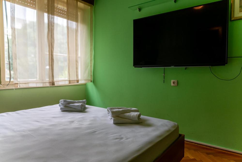 a green bedroom with a bed with a flat screen tv at Apartment Duje in Split