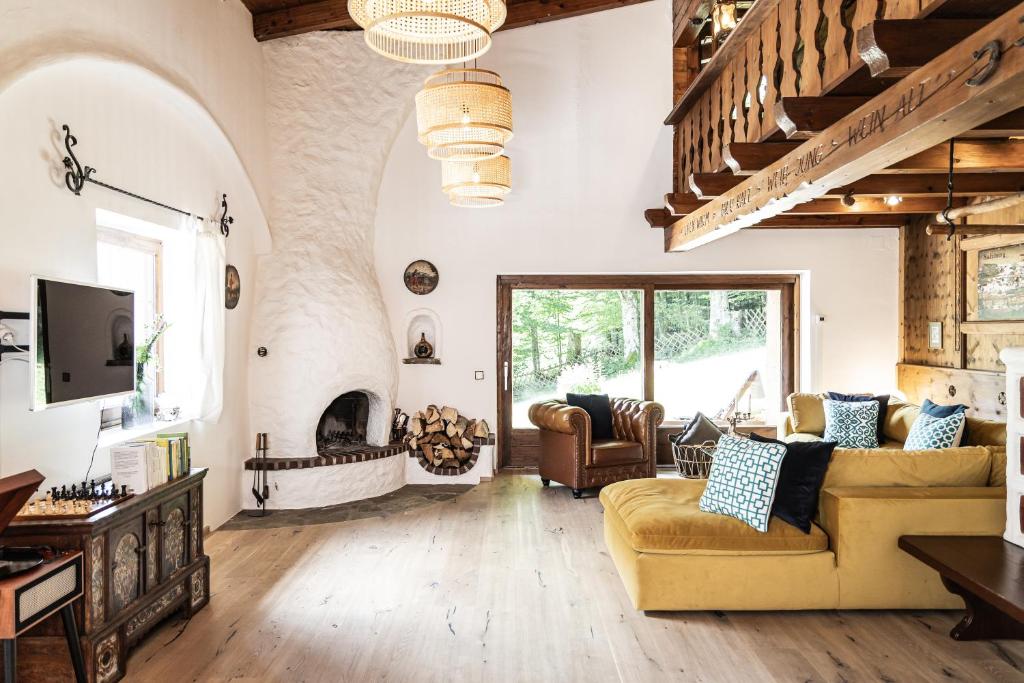 ein Wohnzimmer mit einem Sofa und einem Kamin in der Unterkunft Alpin-Chalet in Alleinlage in Bad Ischl - Wald, Natur, Kamin & Sauna in Bad Ischl