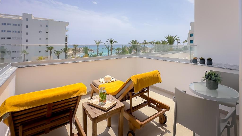 a balcony with two chairs and a table on a roof at Tasia Maris Beach Hotel - Adults Only in Ayia Napa