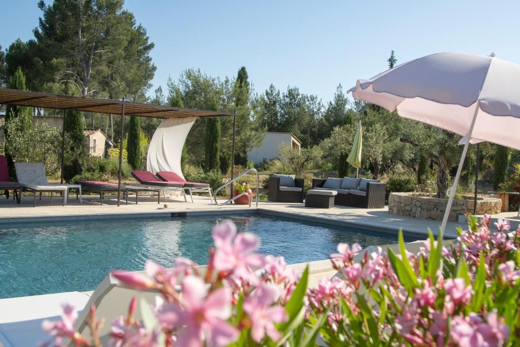 una piscina con sedie, ombrellone e fiori di mas clair de lune a Saint-Rémy-de-Provence
