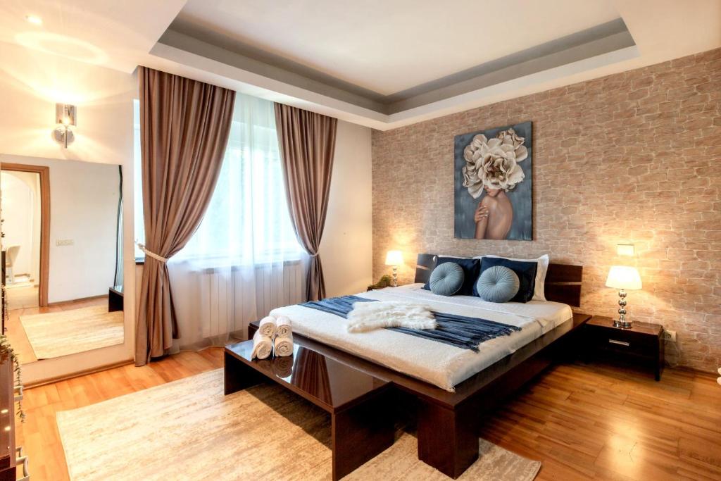 1 dormitorio con 1 cama grande y pared de ladrillo en 1BR Apt with Jacuzzi near Herastrau: Ideal Getaway, en Bucarest