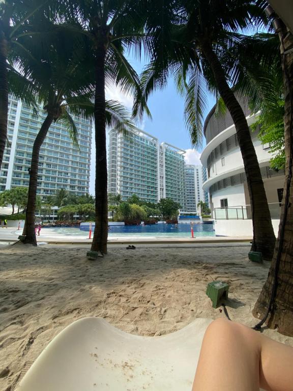 una mujer tumbada en una bañera en la playa con palmeras en Marshall’s Place Azure Staycation, en Manila