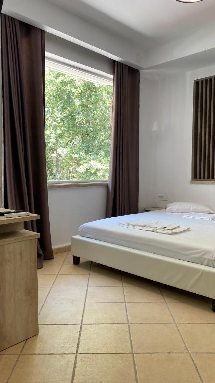 sypialnia z dużym łóżkiem i oknem w obiekcie Emerald Suites w mieście Vryses