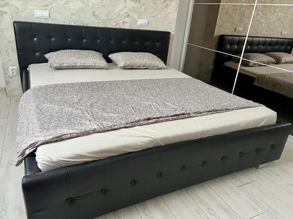 a bed with a black bed frame in a room at Apusului Residence Modern 2 Bedroom Apartment in Roşu