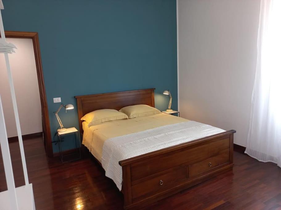 una camera da letto con un letto con una parete blu di Giulia Town House tra città e mare a Salerno