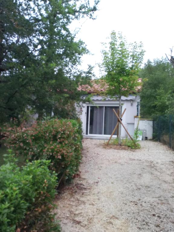 une maison blanche avec une fenêtre et une clôture dans l'établissement Gîte du pech, à Arcambal